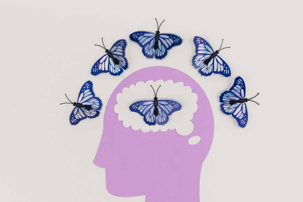 Illustration of blue butterflies emerging from a purple human head outline, symbolizing mental freedom.